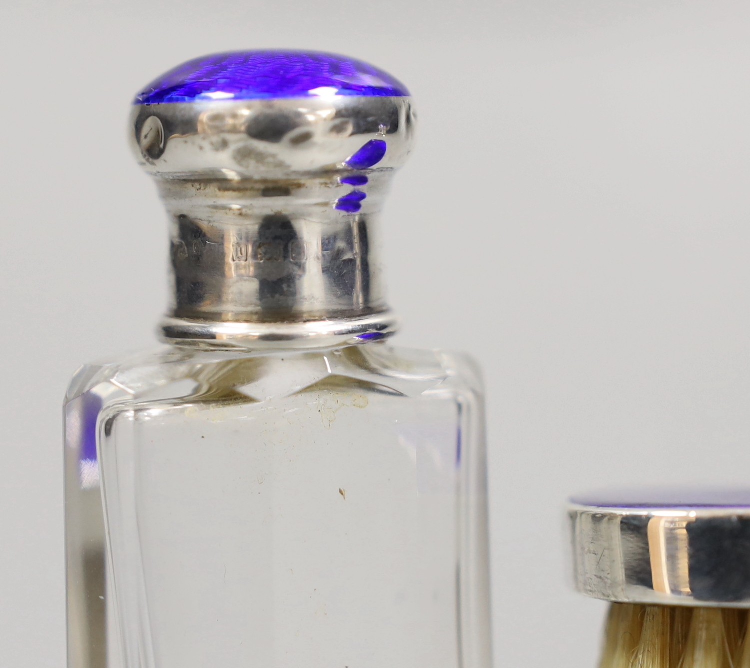 A pair of George V silver and enamel mounted glass scent bottles, 73mm and a small mounted brush, London, 1926.